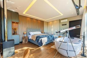 a bedroom with a bed and a bath tub and a telescope at Rancho Carolina Cabana Panther in Rancho Queimado +2 photos