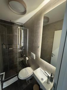 Un baño con inodoro, lavabo y ducha. en UltraCentral NS, en Novi Sad