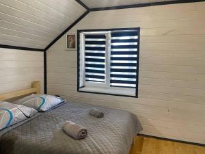a bedroom with a bed in a room with a window at Black & White House in Mykulychyn