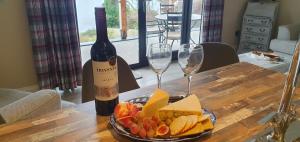 een tafel met een fles wijn en een bord eten bij Carrick Chalets -2 in Carrick +41 foto's