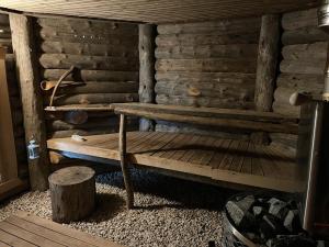 a wooden cabin with a bench in the corner at Villarkala in Heinola