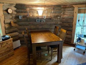 a dining room with a wooden table and chairs at Villarkala in Heinola