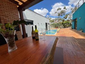 un tavolo di legno con due bottiglie e bicchieri sopra di Casa Cobogó a Brasilia