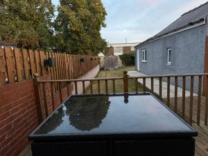 a table in a backyard with a wooden fence at Spacious John York House & Parking in Doncaster