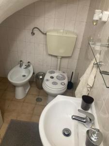 a white bathroom with a toilet and a sink at Rolo House in Nazaré