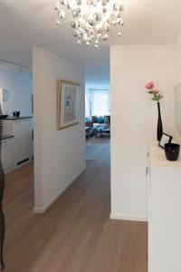 a living room with a chandelier and a vase of flowers at Beautiful apartment near CHIO Tivoli incl underground parking in Würselen