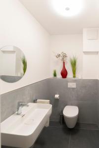 a bathroom with a white sink and a toilet at Beautiful apartment near CHIO Tivoli incl underground parking in Würselen +3 photos