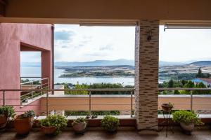 a balcony with a view of the water at Villa Neraida - Panoramic Lake View Retreat in Neráïdha +16 photos