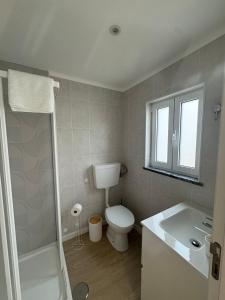 a bathroom with a toilet and a sink at Cantinho do Avô Almeida in Nazaré +7 photos