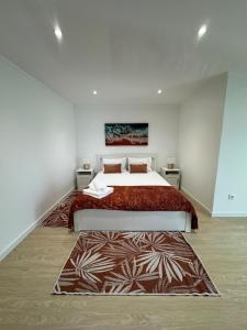 a bedroom with a large bed and a rug at Cantinho do Avô Almeida in Nazaré