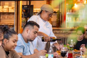 a woman pouring a man a bottle of wine at Tayrona JH Hostels in Los Naranjos