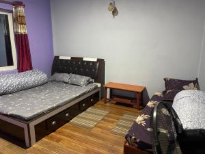 una sala de estar con una cama y una mesa en Aanshi Homestay, en Nagarkot