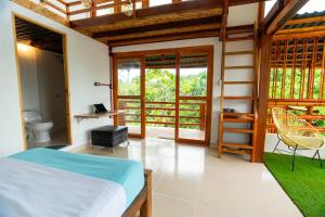 a bedroom with a bed and a balcony at Tayrona JH Hostels in Los Naranjos