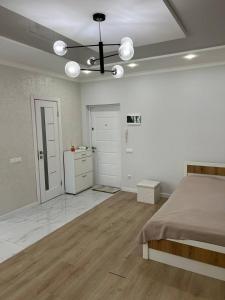 ein weißes Schlafzimmer mit Bett und Küche in der Unterkunft Затишна квартира в Центрі! Новий двір - Galka Apartment in Iwano-Frankiwsk