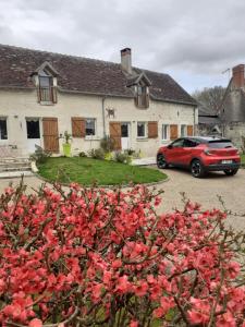 een rode auto geparkeerd voor een huis bij La parenthèse bucolique in Sepmes