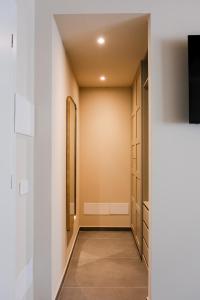 a walk in closet with white walls and a mirror at Tower Studio Triple Suite - Bernina Experience in Tirano