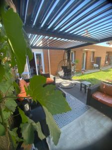 a pergola with a bench and a table on a patio at Atelier chaleureux 40m2 - proche CDG Parc des expo in Tremblay-En-France