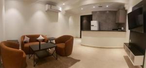 a living room with two chairs and a table at شقة فندقية فاخرة in Taif