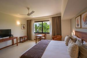 a bedroom with a bed and a television and a desk at Sea Cliff Court Hotel & Luxury Apartments in Dar es Salaam +47 photos