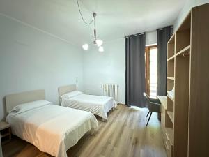 a bedroom with two beds and a desk and a chair at Albergo LA COLDRA in Quarona