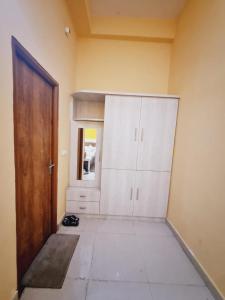 Habitación con armarios blancos, puerta y suelo. en Hotel Clear View, en Mathura