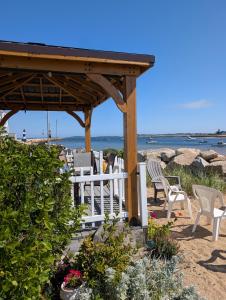 - un kiosque sur la plage avec des chaises et des fleurs dans l'établissement Beach Cottage, à Saco