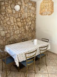 un tavolo con sedie e un muro in pietra di Casa vacacional con piscina a Búzios