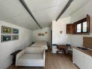 a room with a couch and a table and a sink at Refúgio da Âncora in Colares