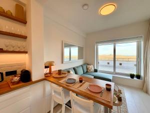 a kitchen and living room with a table and a couch at SEA VIEW Juweeltje in Knokke-Heist