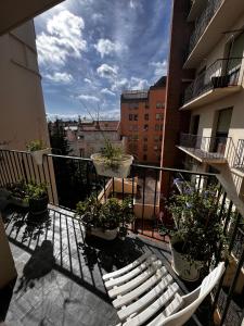 a balcony with two white chairs and potted plants at Le Catalogne 3 in Perpignan