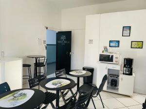 three tables and chairs in a room with a kitchen at Vista Bela Hotel in Pindamonhangaba
