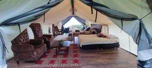 a room with a tent with a bed and chairs at El Color de Mis Rêves in Villamaría