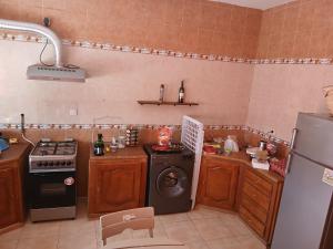 a kitchen with a stove and a dishwasher and a refrigerator at Souhyla in Nabeul