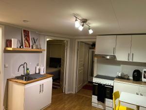 a kitchen with white cabinets and a sink at 2 Bedroom Apartment Tiller in Trondheim +8 photos