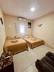 a bedroom with two beds and a window at Kandui Flats Maresias in Maresias +59 photos