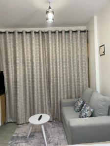 Una sala de estar con un sofá y una ventana. en Luxury Apartments, en Nairobi