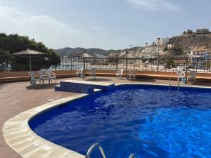 ein Swimmingpool mit Liegen und Blick aufs Wasser in der Unterkunft Vista al mar con piscina in Faro de Cullera