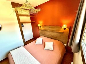 a small room with a bed with two pillows at Bel Appartement 6 personnes au pied des pistes in Chamrousse