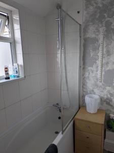 a bathroom with a shower and a bath tub at City Vacations Kettering free WiFi for ' Short & Long stays ' Shared bathroom & Shared Kitchen Double room for 1 - 2 Adults in Kettering +36 photos