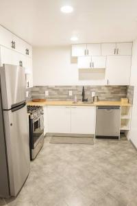 Una cocina con gabinetes blancos y un refrigerador de acero inoxidable. en Iconic Retreat 2BR Home in The Heart Dallas TX, en Oldham