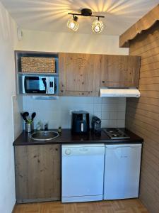 a kitchen with a sink and a stove top oven at Bel Appartement 6 personnes au pied des pistes in Chamrousse