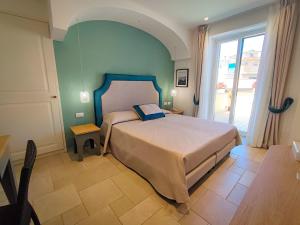 a bedroom with a bed and a large window at Hotel La Pergola in Santa Maria di Castellabate +31 photos