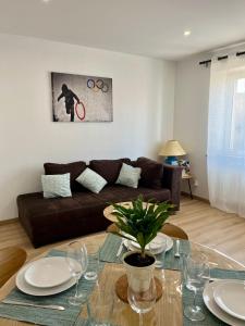 a living room with a couch and a table at L indémodable rénové spacieux et lumineux avec 2 chambres in Sarrebourg