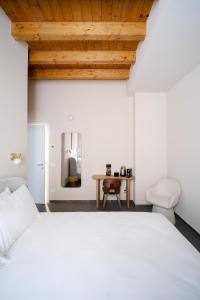 Un dormitorio con una cama blanca y un techo de madera. en Tower Studio Double Suite - Bernina Experience, en Tirano