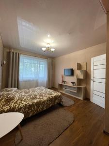 a large bedroom with a bed and a window at Apartamenty. Geroev Krut in Sumy