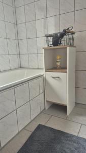 a bathroom with a white tub and a small cabinet at LandOase Buchhorst in Balge +36 photos