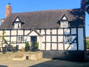 a white and black building with a black roof at Cefn Farm - Hyssington Heights in Hyssington