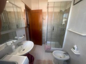 a bathroom with a sink and a shower and a toilet at Villino con giardino a 10 minuti a piedi dal mare e vicino a Roma in Torvaianica +18 photos