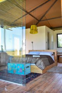 a bedroom with a bed with a glass wall at Ole-lekurruki Naromoru Cabins in Naro Moru +48 photos