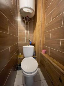 a small bathroom with a toilet and a tank at Apartamenty. Geroev Krut in Sumy